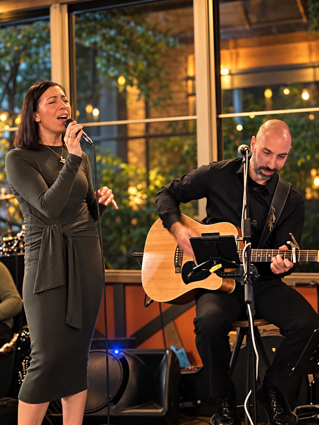 Dan playing guitar alongside a female vocalist during an acoustic duo performance